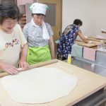 小池さん(左)の指導でうどん打ちに挑戦