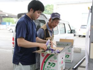 出荷するエダマメを確認するJA職員と野口部会長(右)