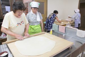 小池さん（左）の指導でうどん打ちに挑戦